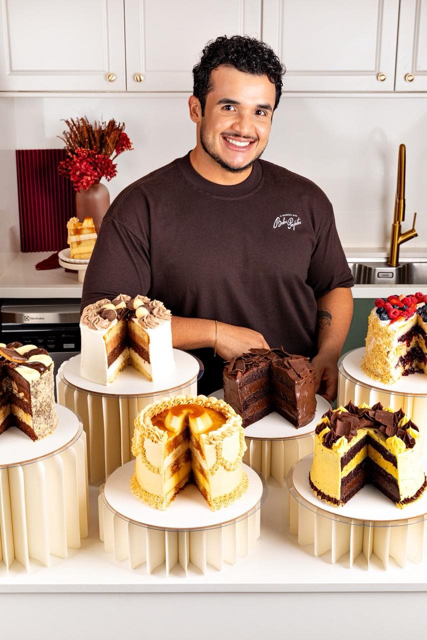 Igor na cozinha cercado por diversos bolos
